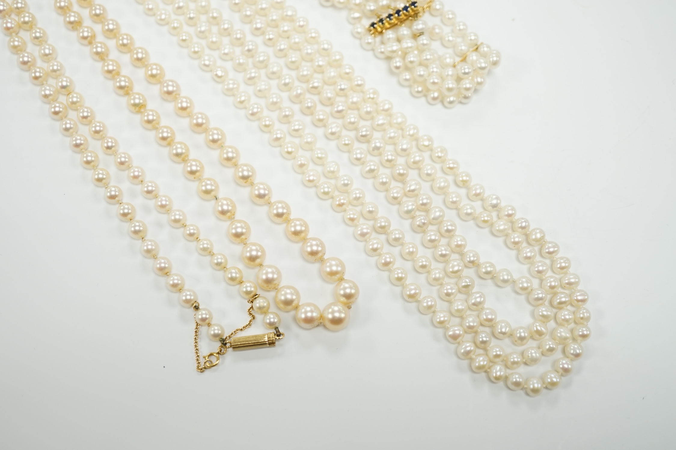 Two Cultured pearl necklaces including a triple strand with yellow metal and sapphire set clasp, 46cm and a matching bracelet.